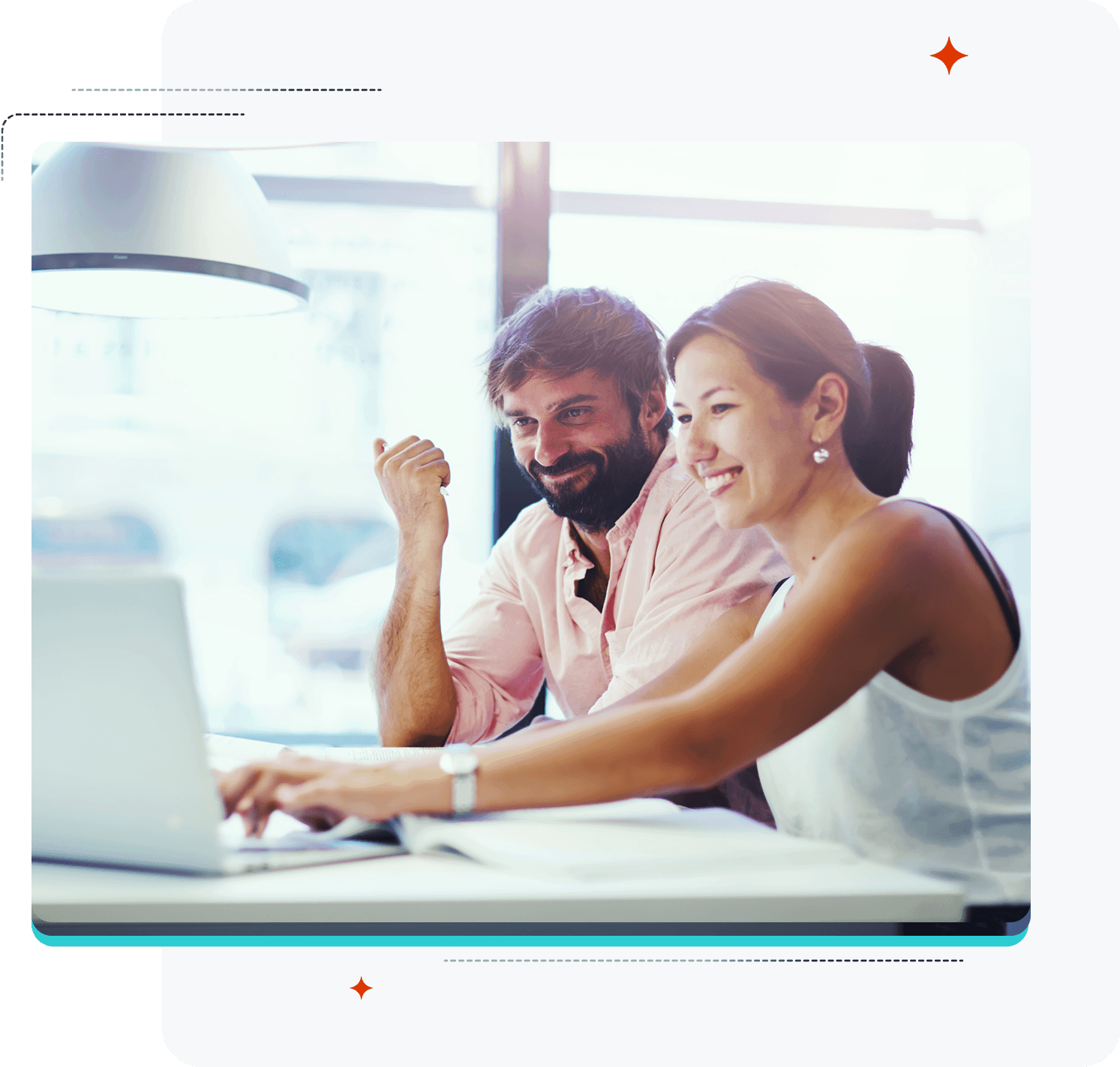 Due persone sorridenti che lavorano al computer portatile.